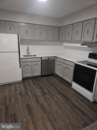 a kitchen with granite countertop white cabinets and white appliances