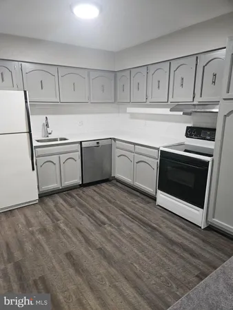 a kitchen with white cabinets stainless steel appliances and sink