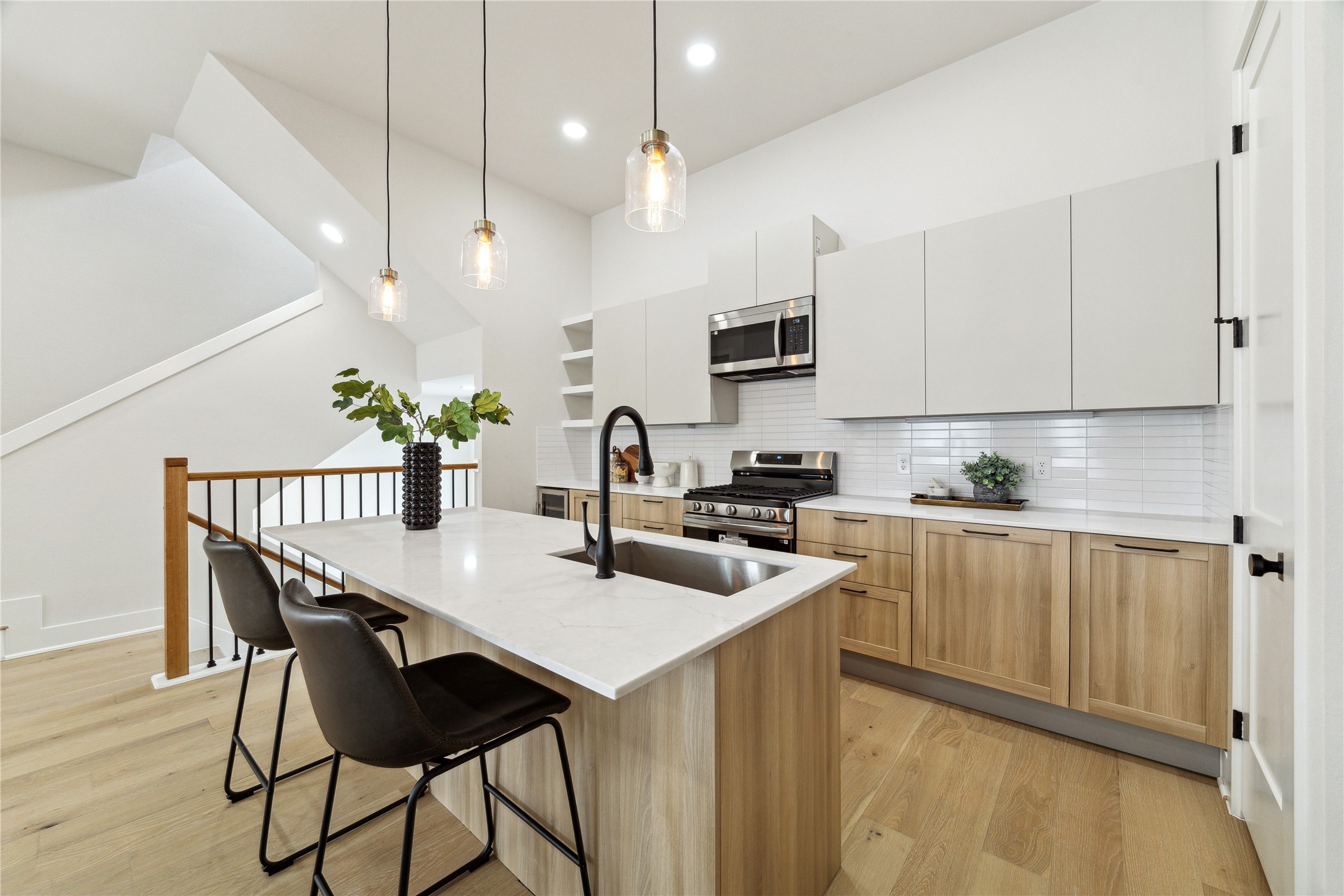 Sleek, modern kitchen featuring stainless steel appliances, elegant cabinetry, and a spacious island with seating. Perfect for cooking and entertaining.