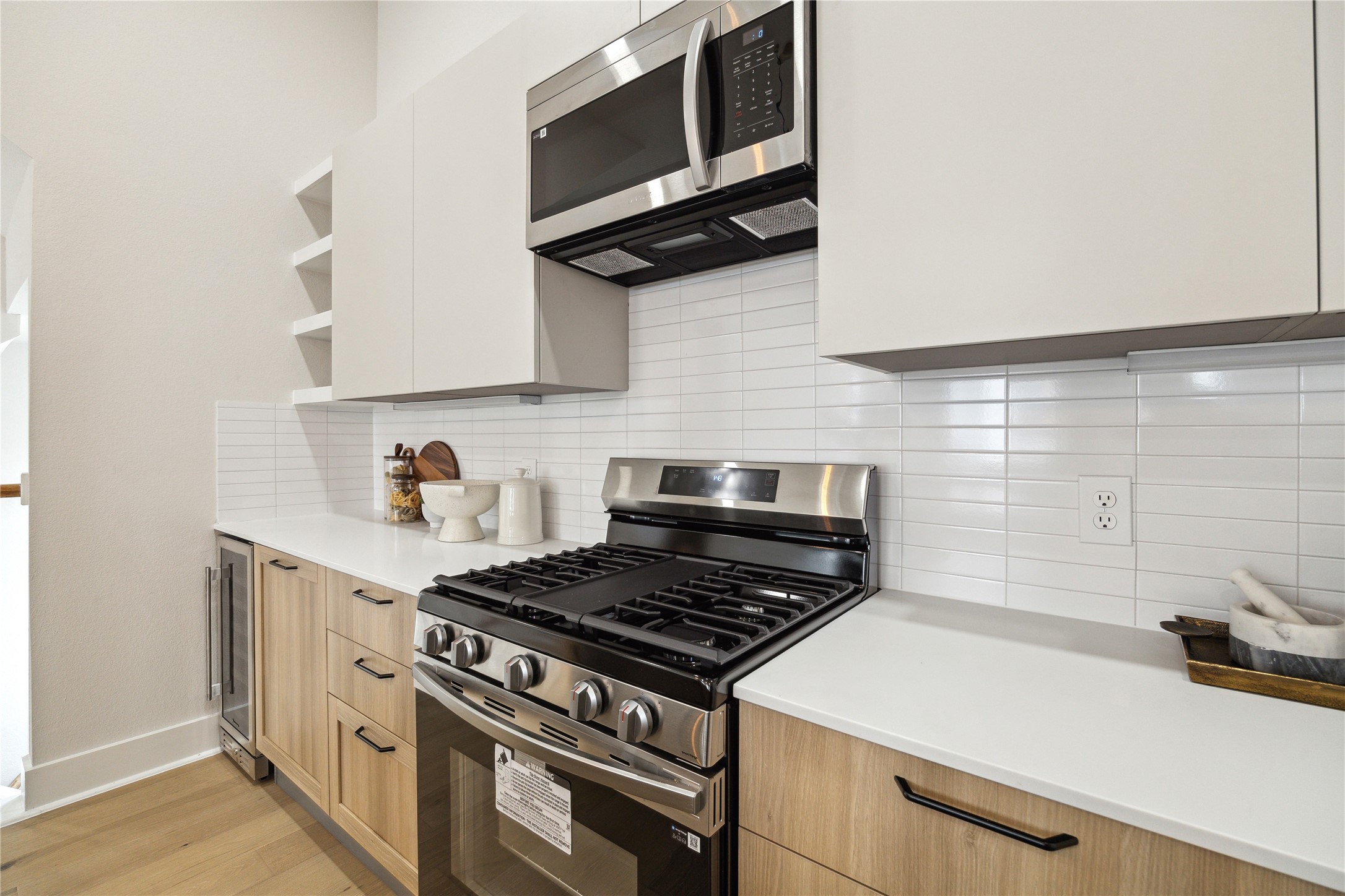 3911 Tulane Street, Unit B Houston, TX 77018 - Photo 5 of 37 Modern kitchen featuring sleek cabinetry, stainless steel appliances, and a stylish tile backsplash, perfect for culinary enthusiasts.