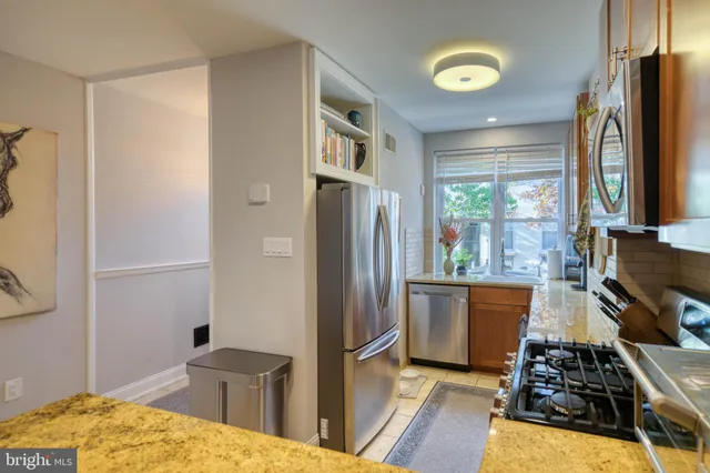 a kitchen with stainless steel appliances granite countertop a refrigerator stove and sink