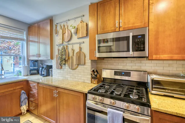a kitchen with stainless steel appliances granite countertop a stove and a microwave