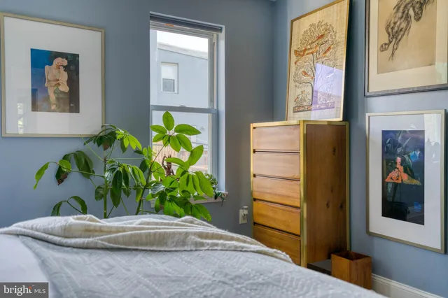 a plant with a vase of flowers on a table with wooden floor