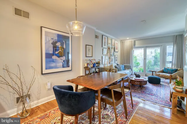 a dining room with furniture a chandelier and wooden floor