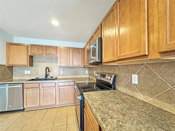 a kitchen with stainless steel appliances granite countertop a sink and cabinets