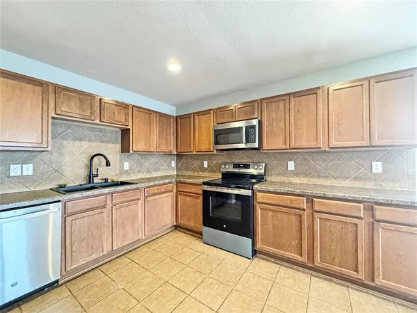 a kitchen with cabinets appliances and a sink
