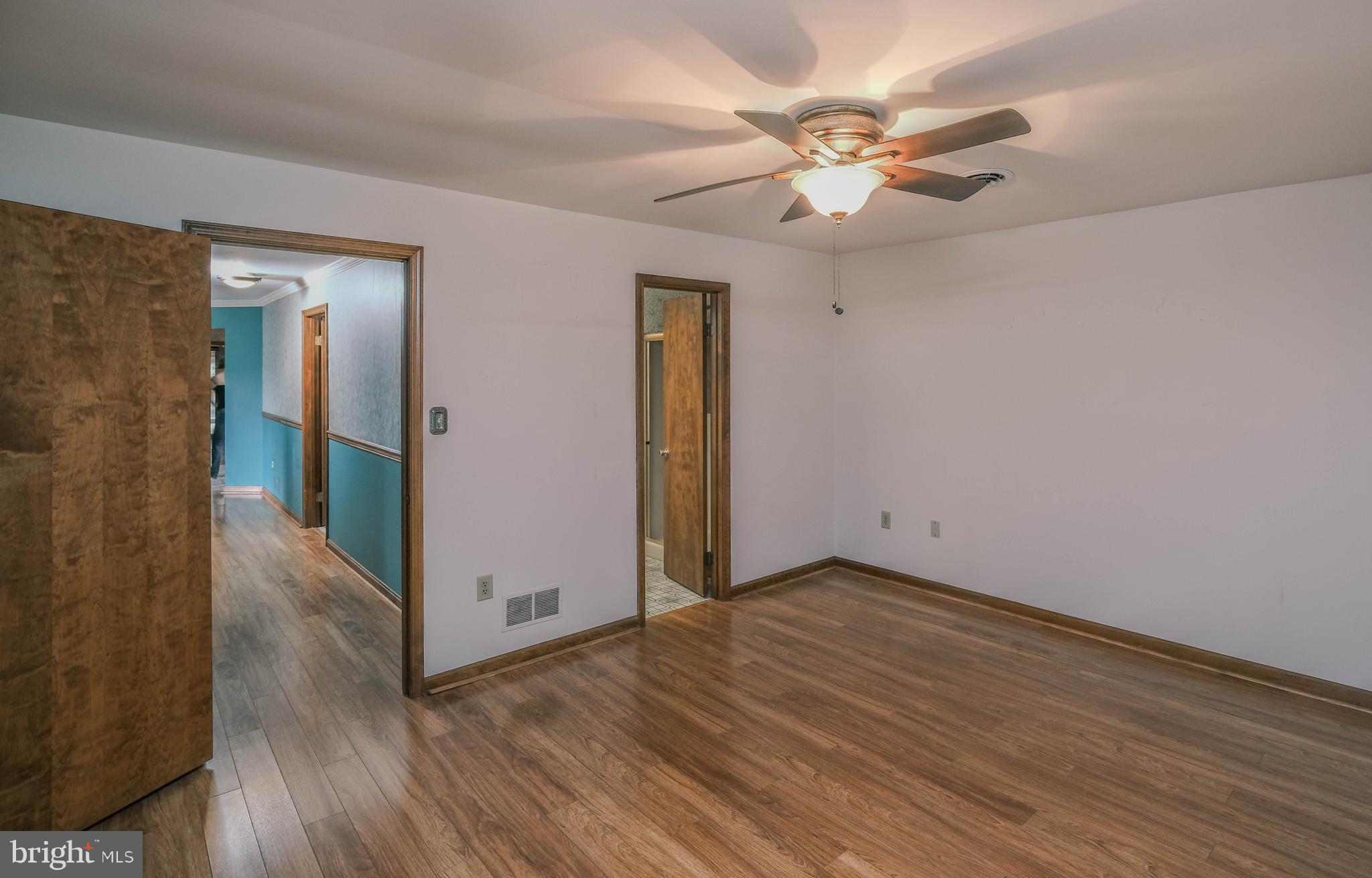 225 Bowling Green Road Front Royal, VA 22630 - Photo 32 of 77 an empty room with wooden floor fan and windows