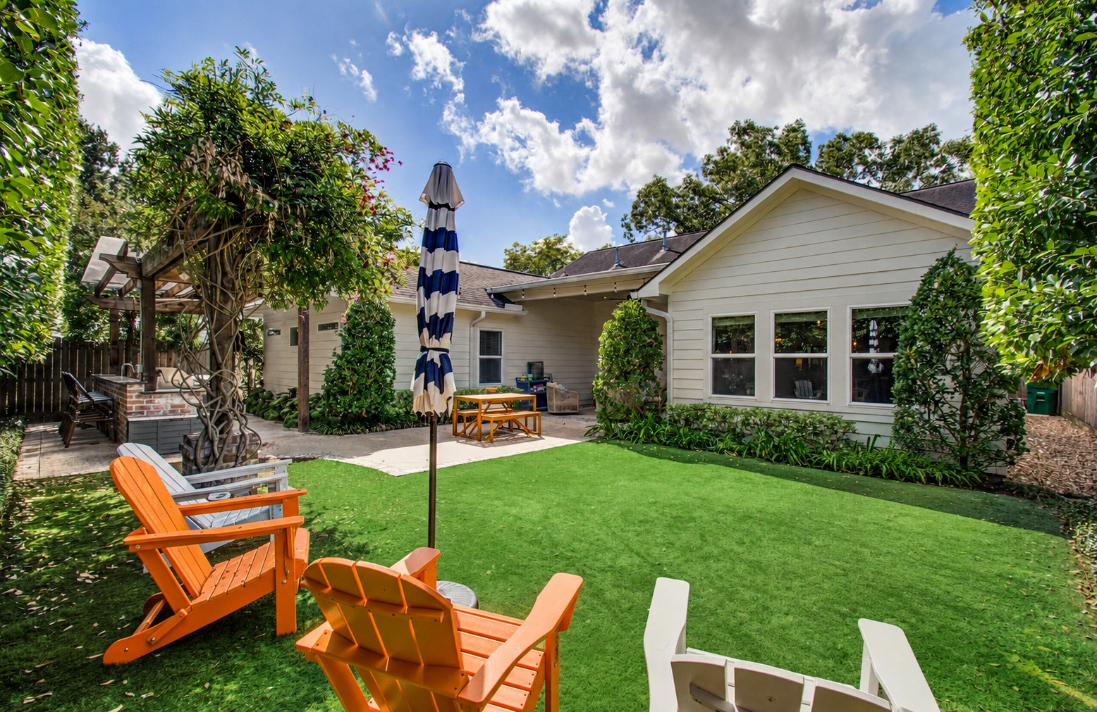 1722 Chippendale Road Houston, TX 77018 - Photo 31 of 41 Charming backyard oasis featuring a lush artificial lawn, and a stylish pergola with a cozy seating area perfect for relaxation and entertaining.