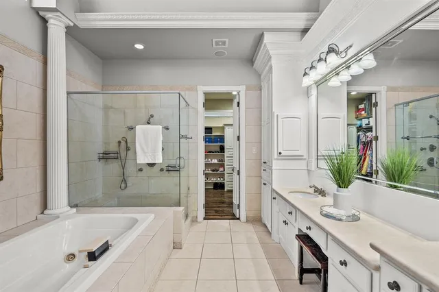 a spacious bathroom with a granite countertop tub sink a mirror a shower and vanity