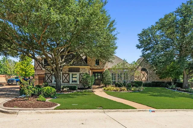 a front view of a house with a garden and tree