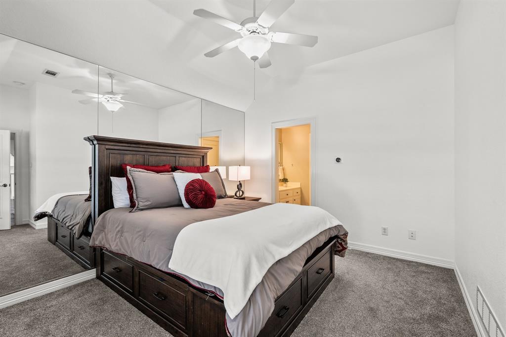 1101 Trail Ridge Drive McKinney, TX 75072 - Photo 25 of 37 a bedroom with a bed and a chandelier