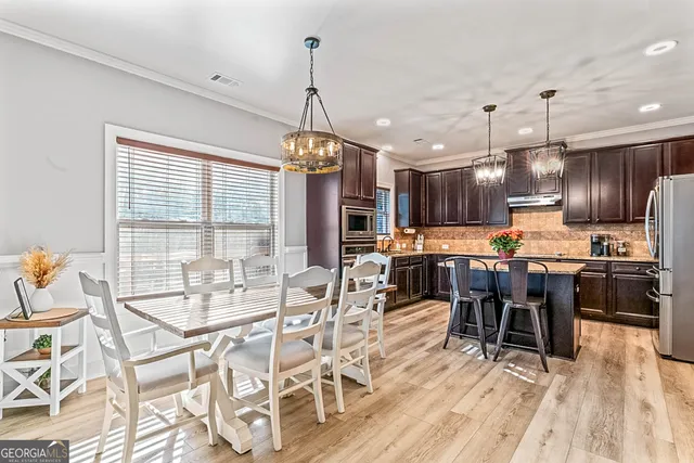 a view of a dining room with furniture a chandelier and wooden floor