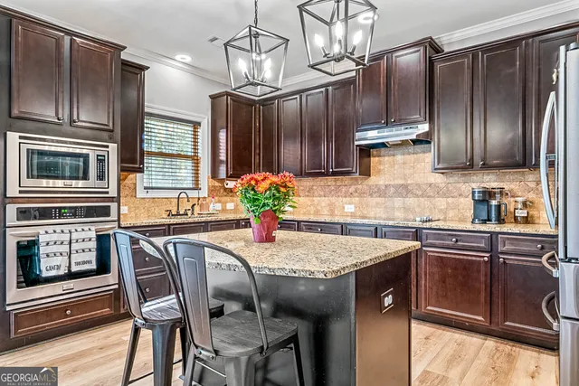 a kitchen with stainless steel appliances granite countertop a sink stove and refrigerator
