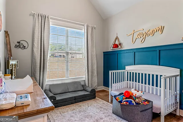 a bedroom with a bed a mirror and a flat tv screen on a dresser