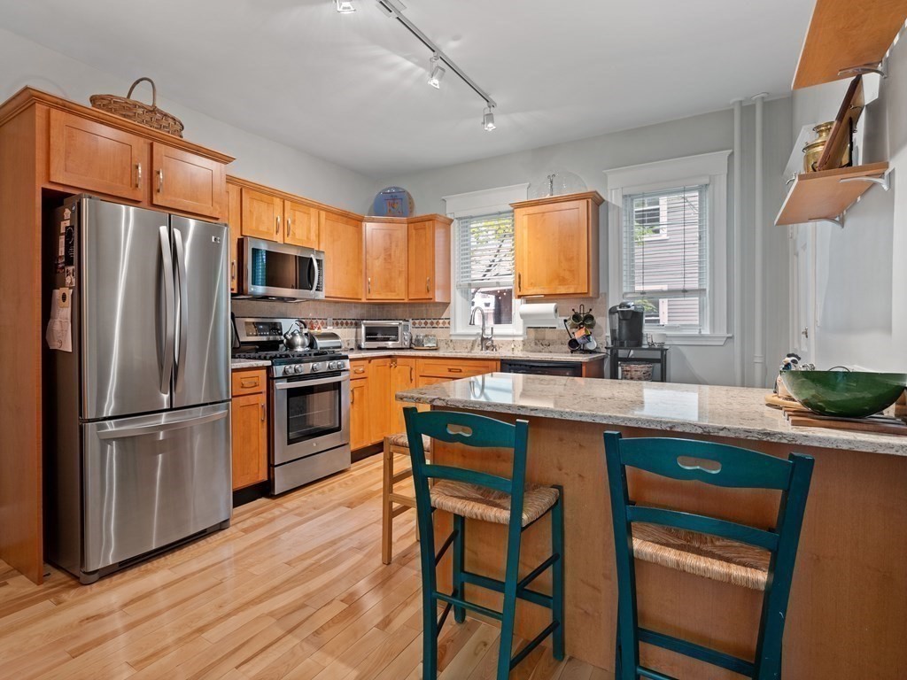68 Parkton Road, Unit 1 Boston, MA 02130 - Photo 8 of 22 a kitchen with stainless steel appliances granite countertop a stove a sink dishwasher a refrigerator with a dining table and chairs