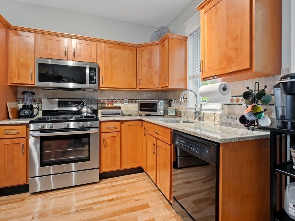 68 Parkton Road, Unit 1 Boston, MA 02130 - Photo 10 of 22 a kitchen with stainless steel appliances granite countertop a stove top oven microwave and cabinets