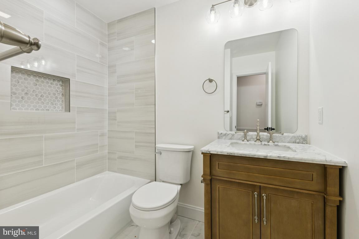 3209 Military Road Arlington, VA 22207 - Photo 19 of 45 a bathroom with a sink a toilet and shower