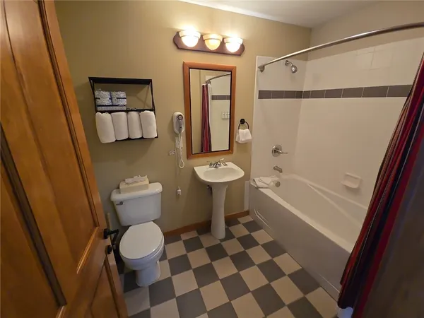 a bathroom with a toilet a sink and mirror