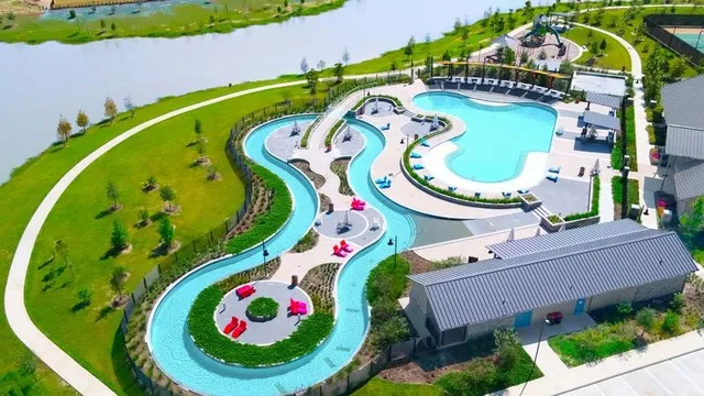 an aerial view of a swimming pool with a yard and plants
