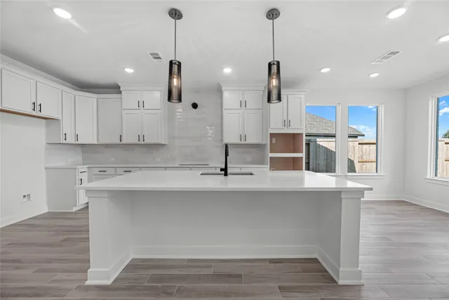 a kitchen with kitchen island a counter top space a sink appliances and cabinets