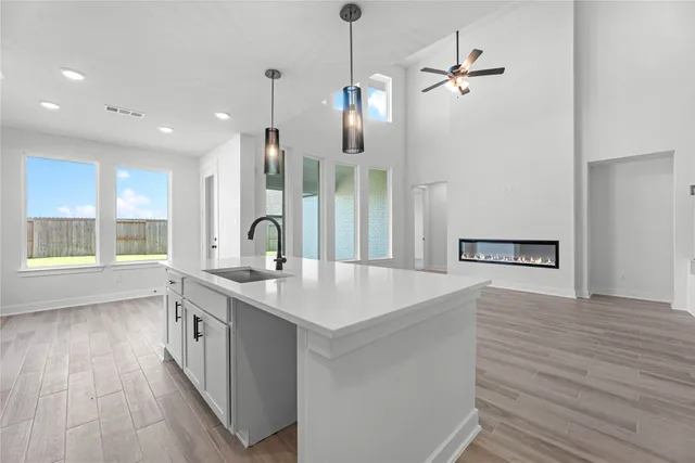 a large kitchen with sink a large window and stainless steel appliances