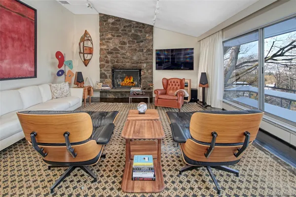 a dining room with furniture and a floor to ceiling window