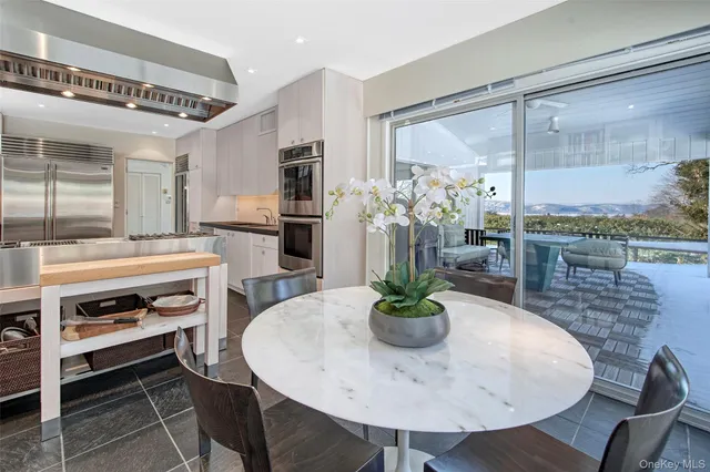 a dining room with furniture and a floor to ceiling window