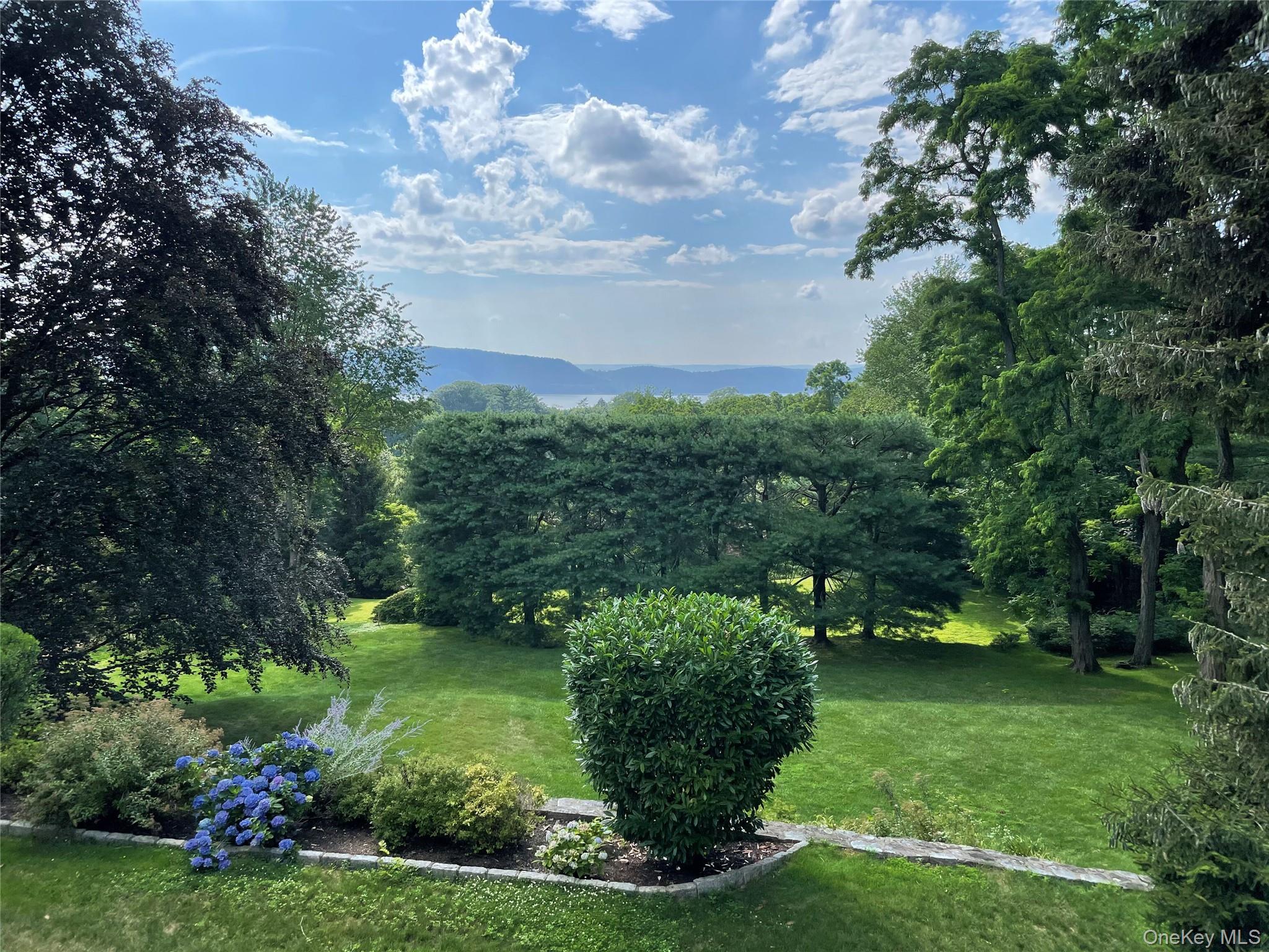 132 Ridgecrest Road Briarcliff Manor, NY 10510 - Photo 42 of 48 a view of a garden with lawn chairs and a large tree