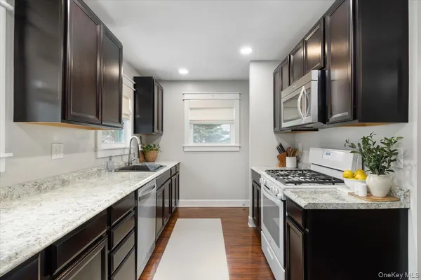 a kitchen with stainless steel appliances granite countertop a sink stove and cabinets