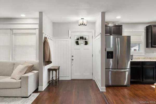 a kitchen with stainless steel appliances wooden floor and a refrigerator