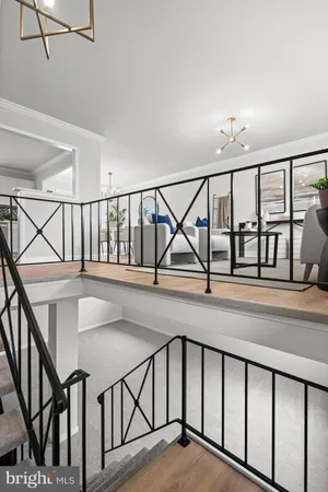 a view of staircase with lots of frames on wall and a window