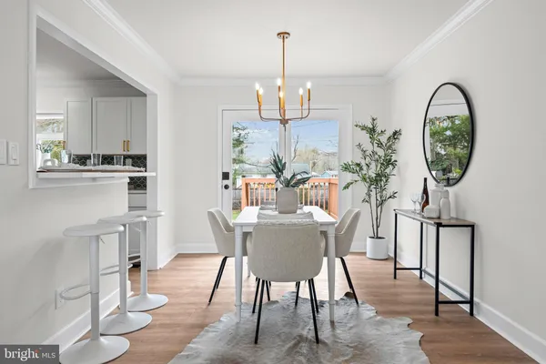 a dining room with furniture a chandelier and wooden floor
