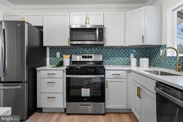 a kitchen with white cabinets and stainless steel appliances