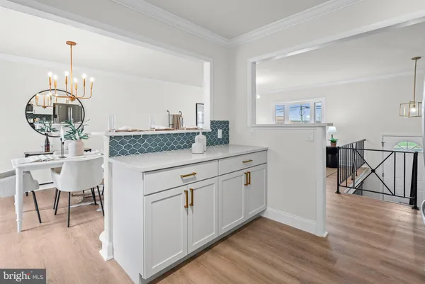 a kitchen with granite countertop white cabinets and wooden floor