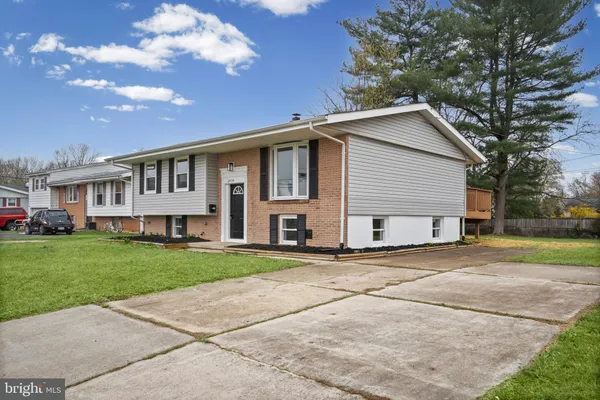 a view of a yard in front of a house with a large tree