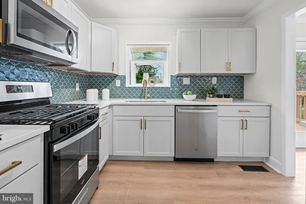 a kitchen with white cabinets and appliances