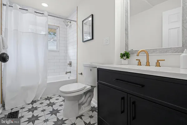 a bathroom with a sink toilet vanity and shower