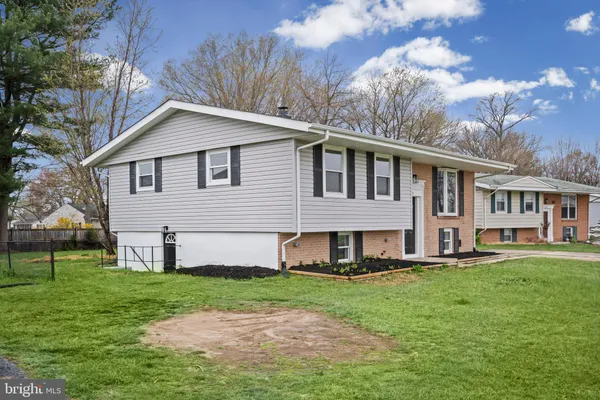 a front view of a house with a yard and trees