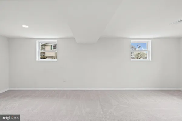 an empty room with a painting on the wall and a window