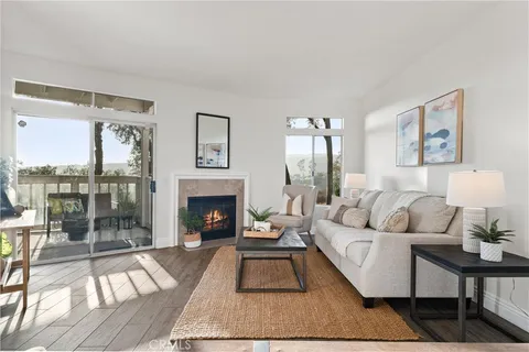 a living room with furniture a large window and a fireplace
