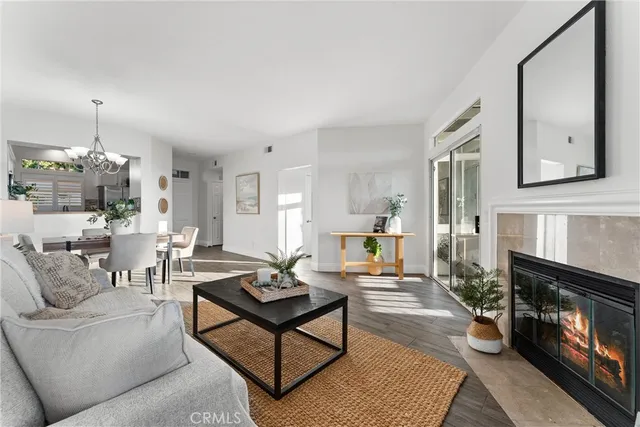 a living room with furniture a fireplace and a chandelier