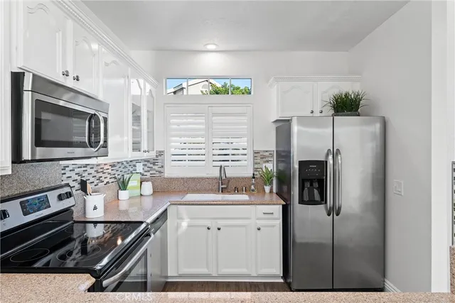 a bedroom with a bed and a potted plant on the dresser