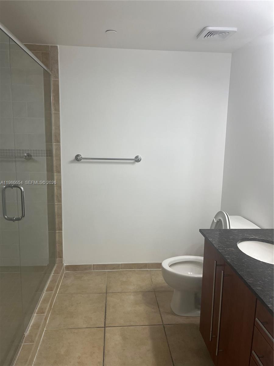 7350 Southwest 89th Street, Unit 1801S Miami, FL 33156 - Photo 14 of 15 a bathroom with a granite countertop sink a toilet and a mirror