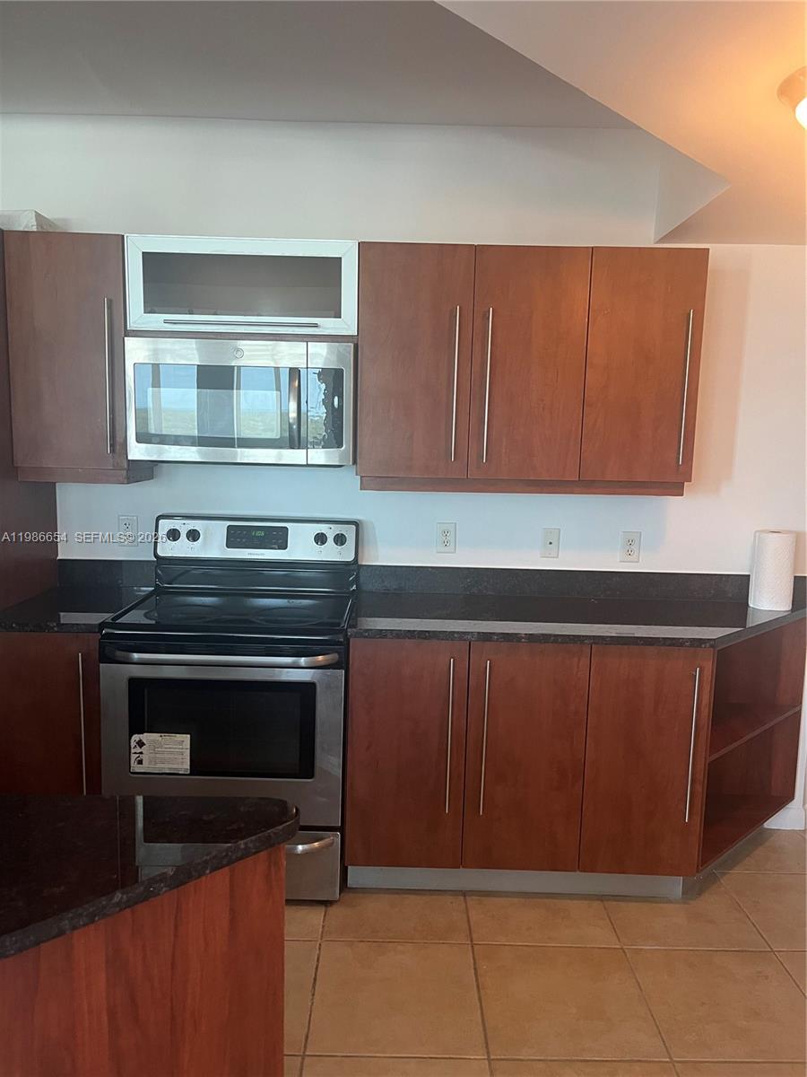 7350 Southwest 89th Street, Unit 1801S Miami, FL 33156 - Photo 7 of 15 a kitchen with granite countertop cabinets and steel stainless steel appliances