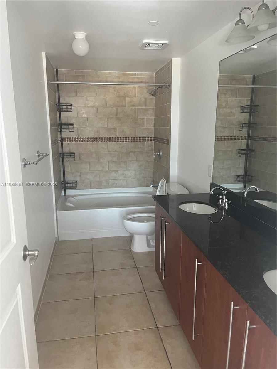 7350 Southwest 89th Street, Unit 1801S Miami, FL 33156 - Photo 9 of 15 a bathroom with a granite countertop sink a toilet and shower