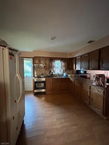 a kitchen with stainless steel appliances granite countertop a refrigerator sink and stove