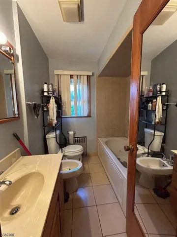 a bathroom with a tub sink and mirror