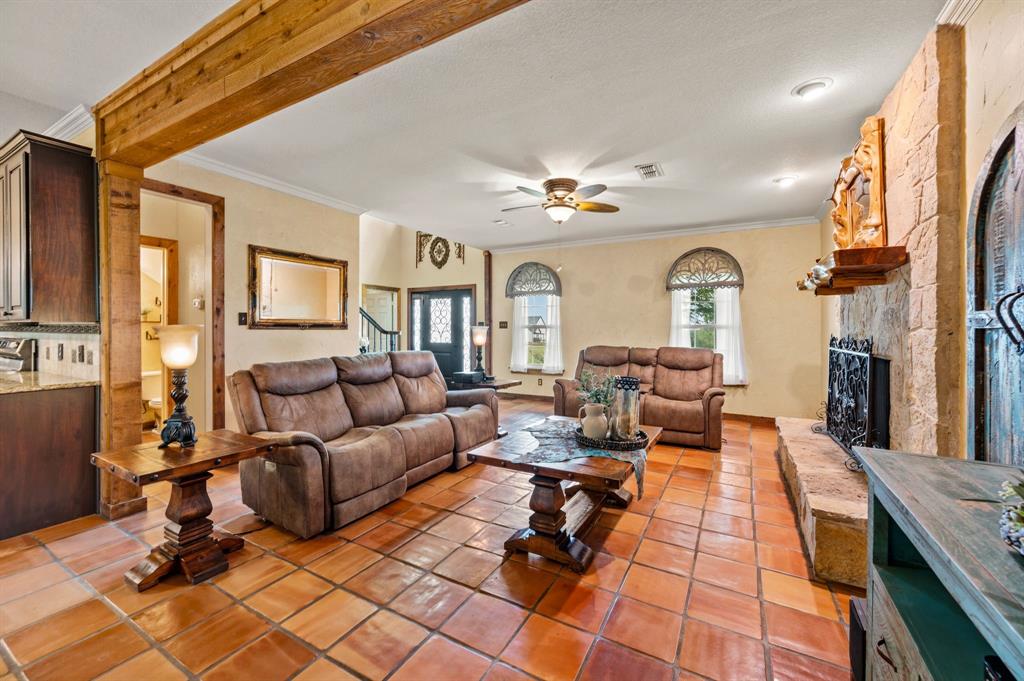 2141 Old Denton Road Decatur, TX 76234 - Photo 11 of 40 Spacious living area with exposed wood beam and a stone fireplace.