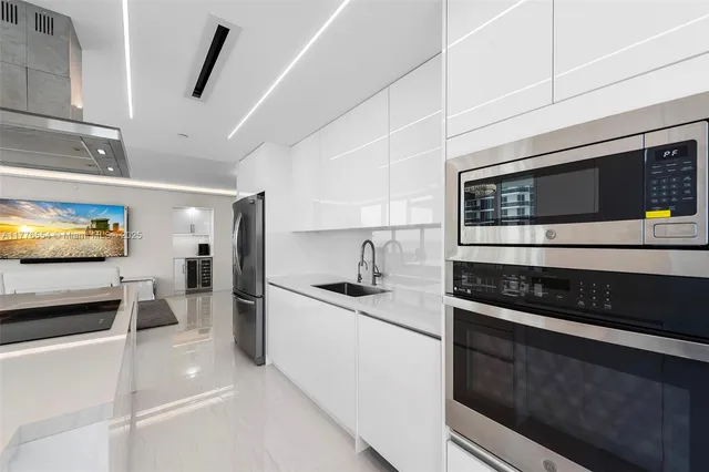 a kitchen with stainless steel appliances a stove a sink and a microwave