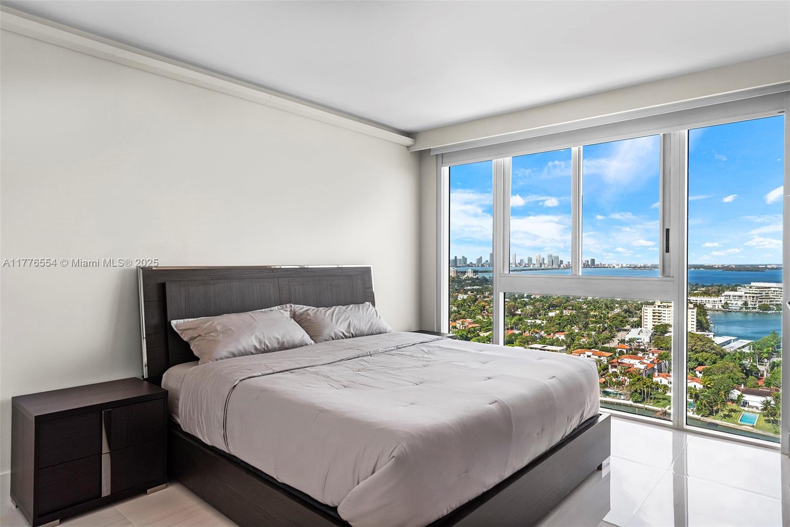 4775 Collins Avenue, Unit 2607 Miami Beach, FL 33140 - Photo 14 of 48 a bedroom with a large window and a bed